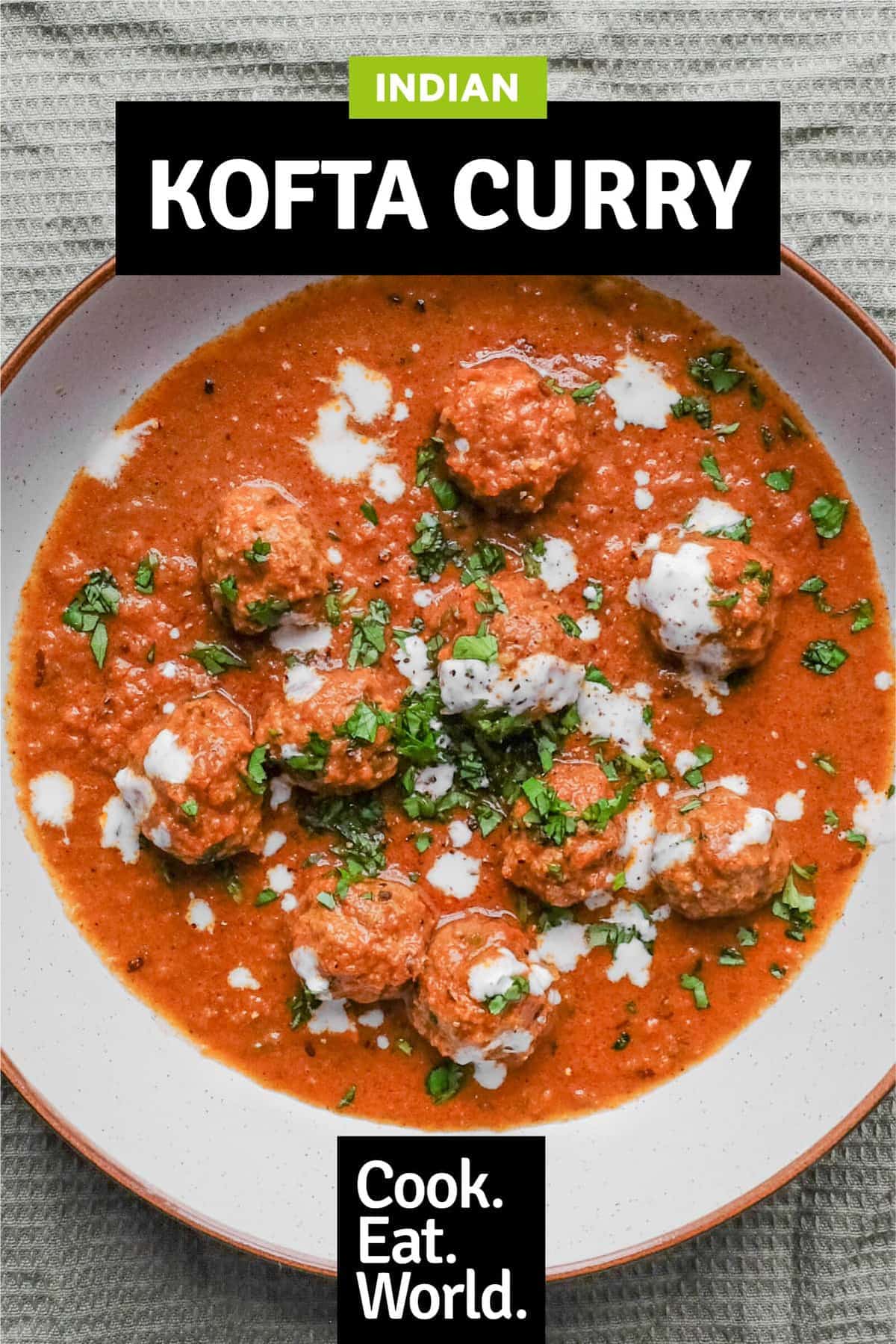 A bowl of Kofta (meatball) curry drizzled with yoghurt and garnished with chopped cilantro