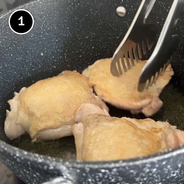 Growing the skin on three chicken thighs in a pan.