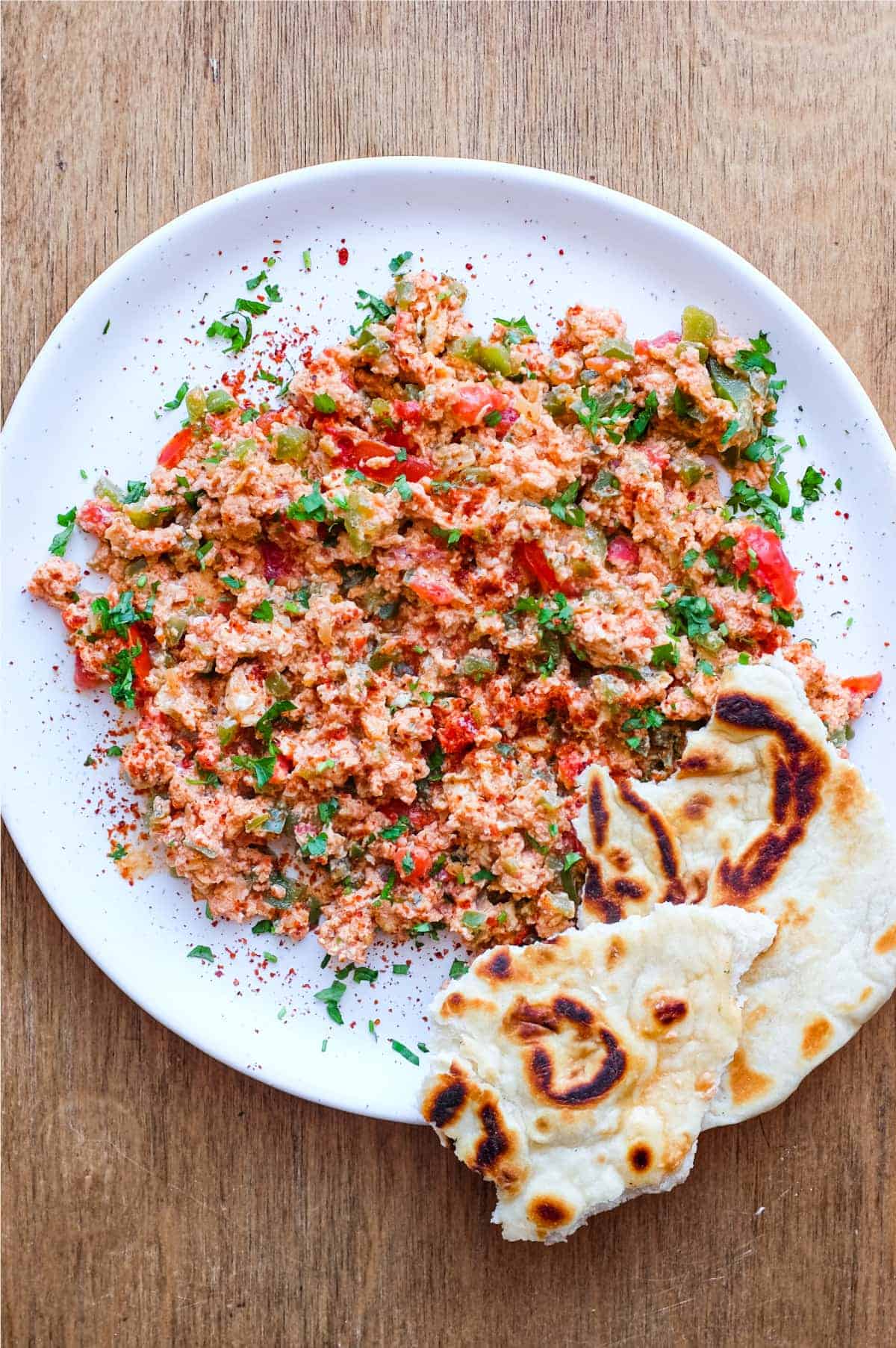 A plate of Turkish Menemen with flatbreads on the side