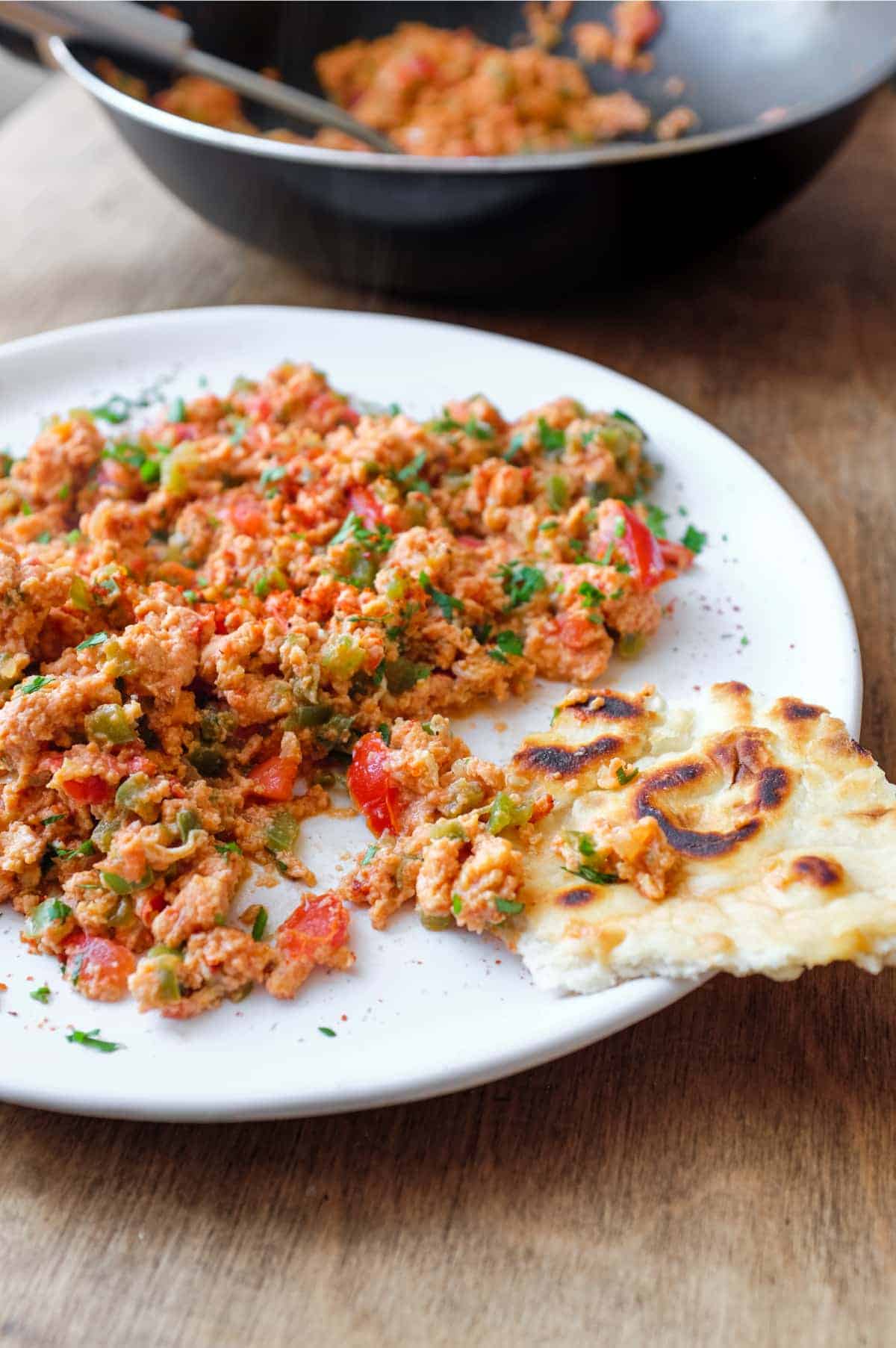 A plate of Turkish Menemen with flatbreads on the side