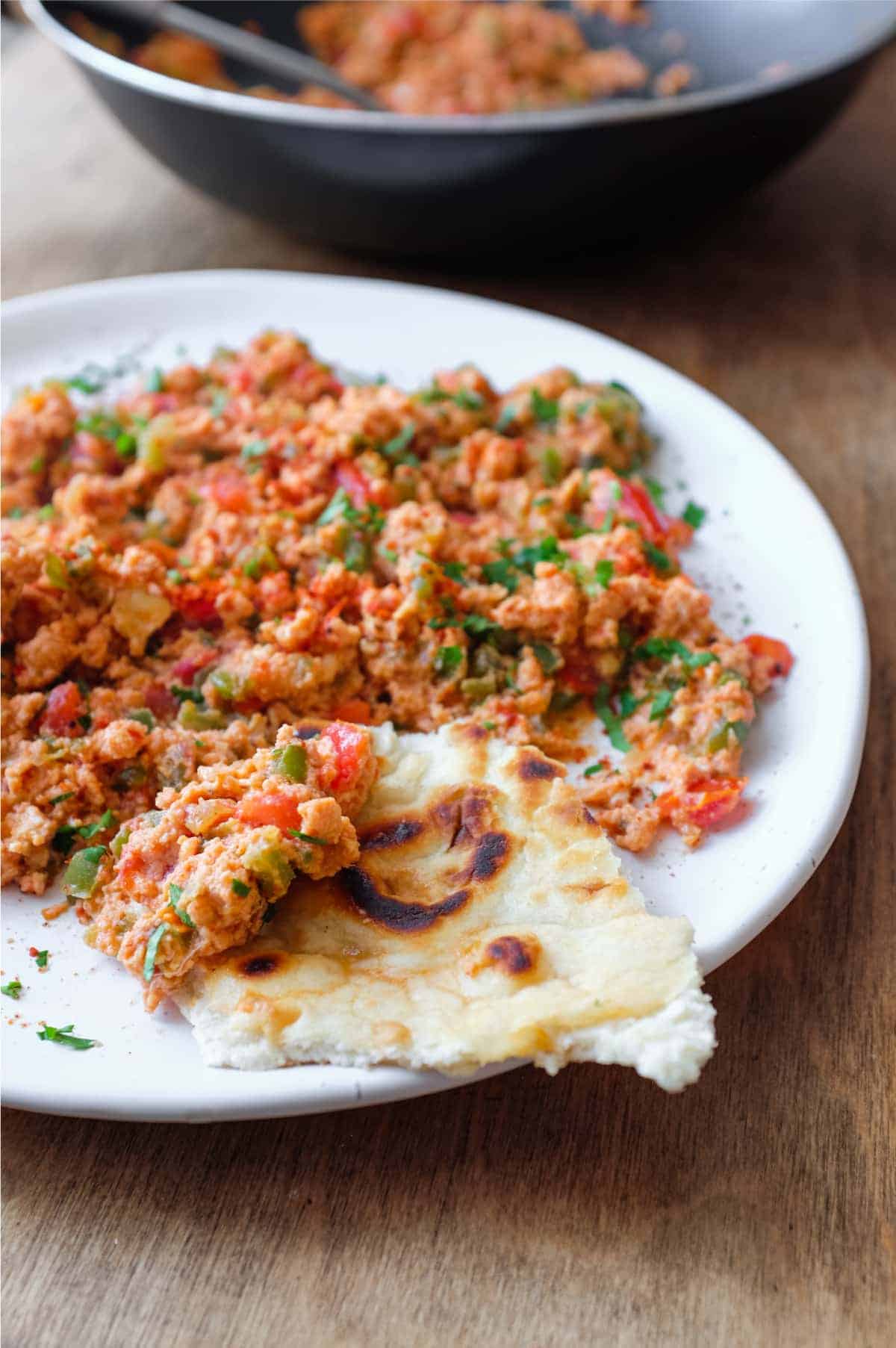 A plate of Turkish Menemen with flatbreads on the side