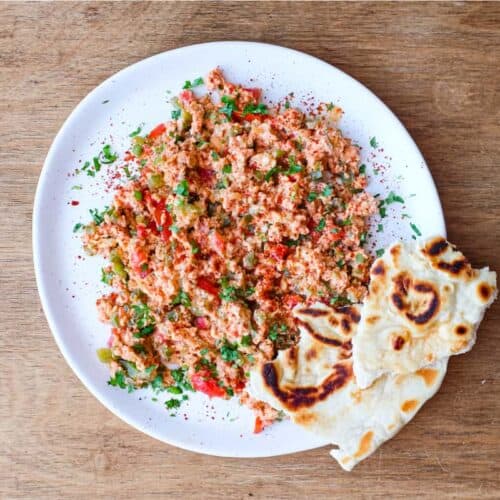 A plate of Turkish Menemen with flatbreads on the side
