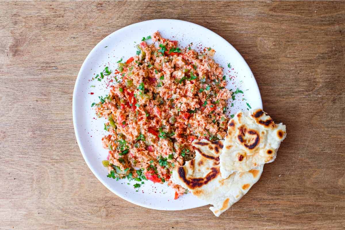 A plate of Turkish Menemen with flatbreads on the side