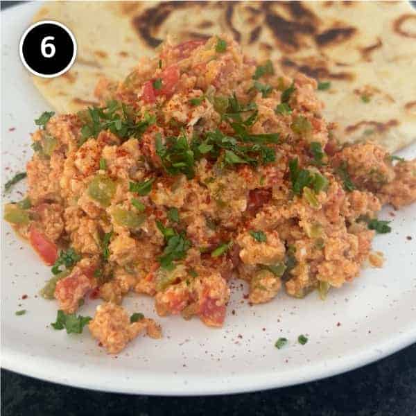 A plate of Turkish Menemen with flatbreads on the side