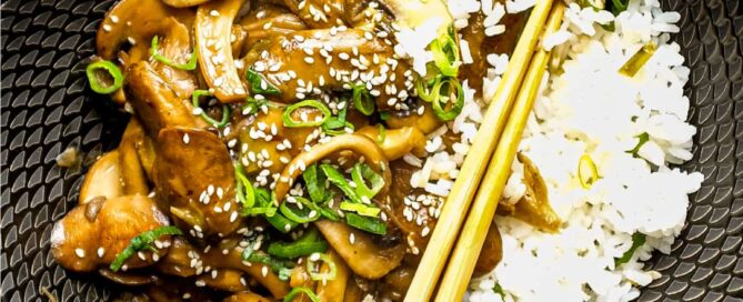 A bowl of rice topped with sautéed miso mushrooms. Chopsticks sit alongside the bowl.