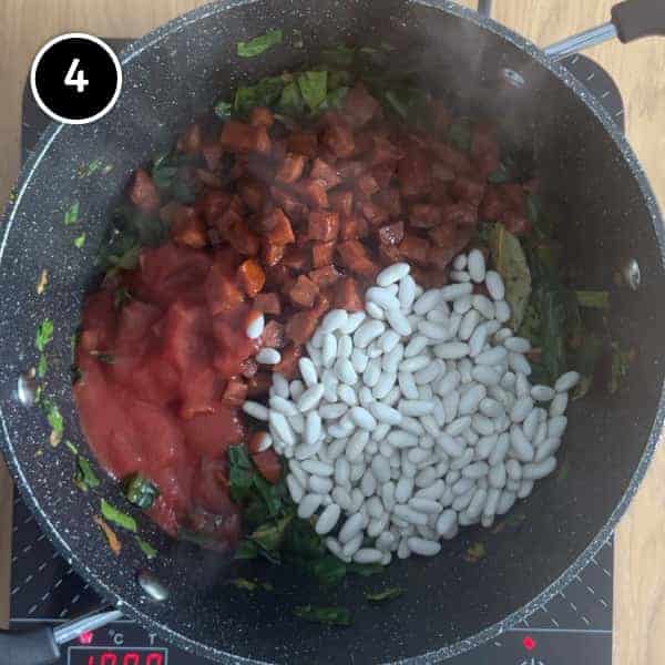 Beans, chorizo and tomato passata added to the pan for a bean and chorizo stew.