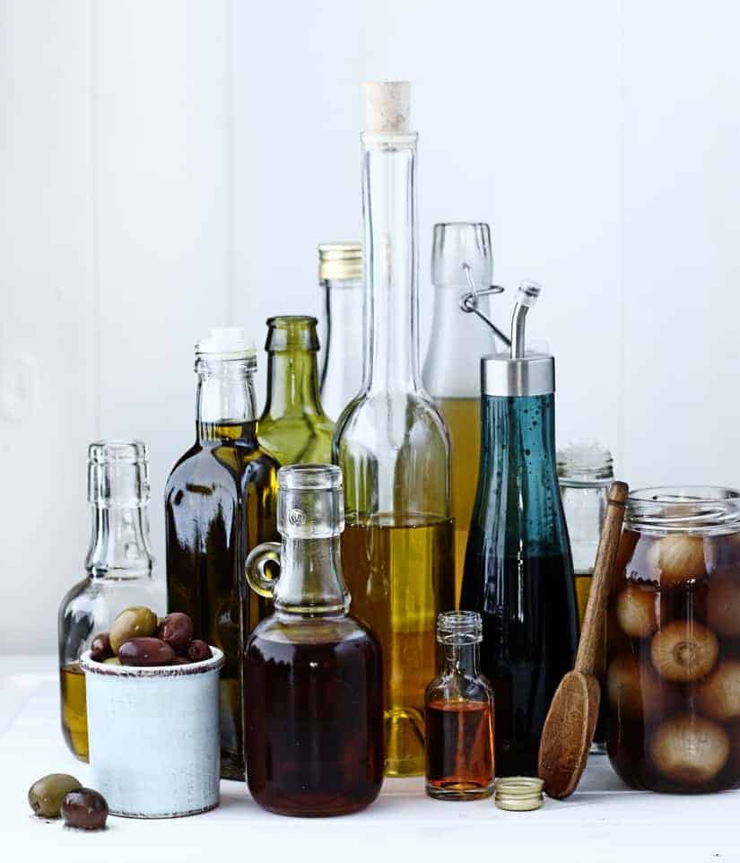 A selection of glass bottles holding oils and vinegars
