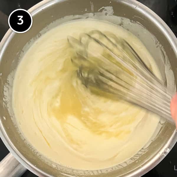 Whisking the lemon and sugar into the warm cream and mascarpone.