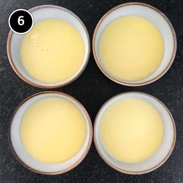 four bowls of the cream sit on a bench top waiting to be refrigerated.