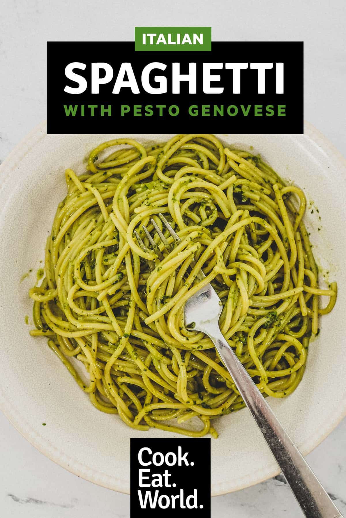 A bowl of Spaghetti with Pesto Genovese. A fork twists around a few noodles.