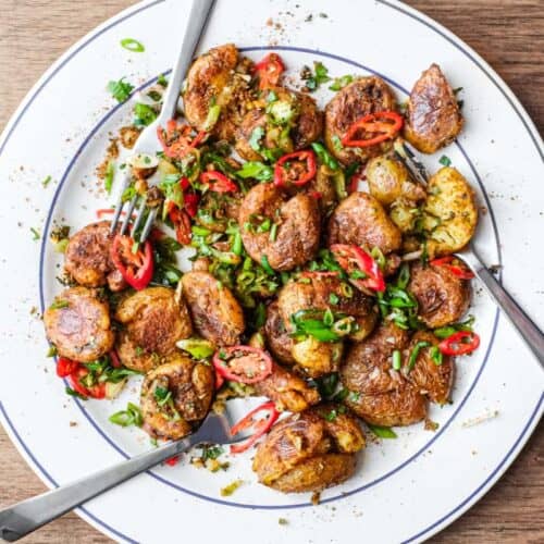 A platter of Indian Gunpowder potatoes tossed in a spice mix and fresh spring onion, chillies and cilantro