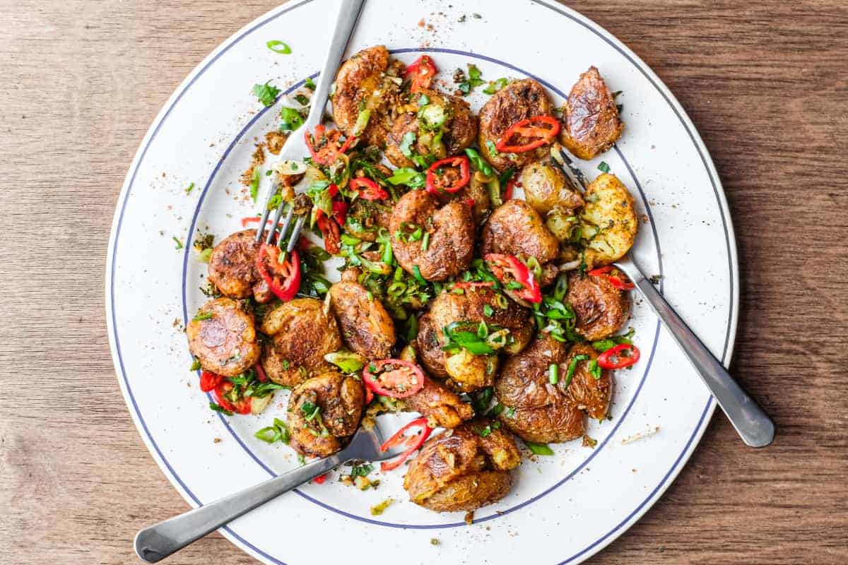 A platter of Indian Gunpowder potatoes tossed in a spice mix and fresh spring onion, chillies and cilantro
