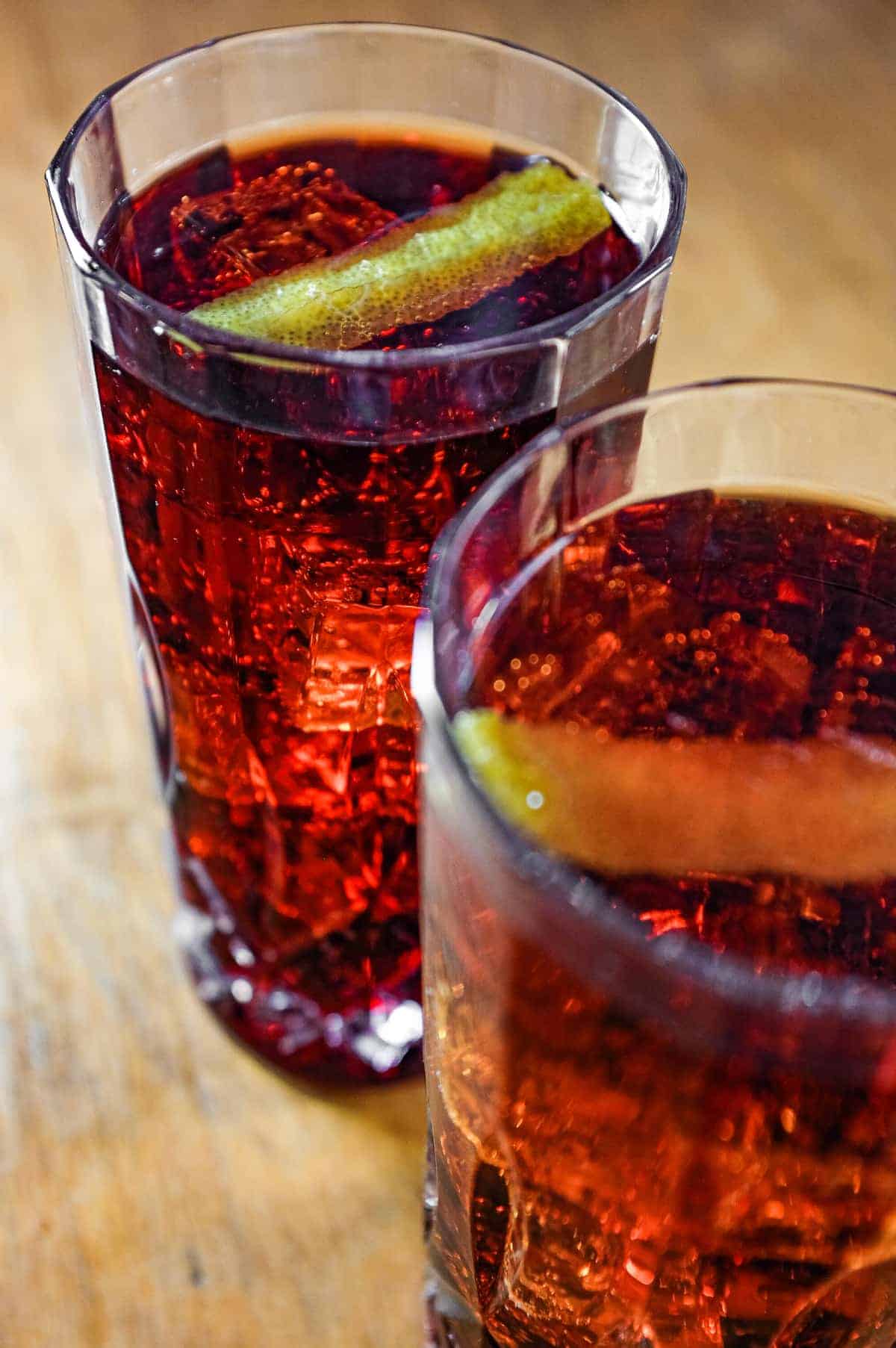 Two cut glass highball glasses of a cocktail called Picon Punch