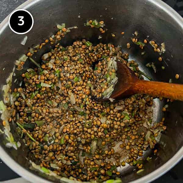Italian Sausage and Lentils | cookeatworld.com Lentils being stirred in a small pan.