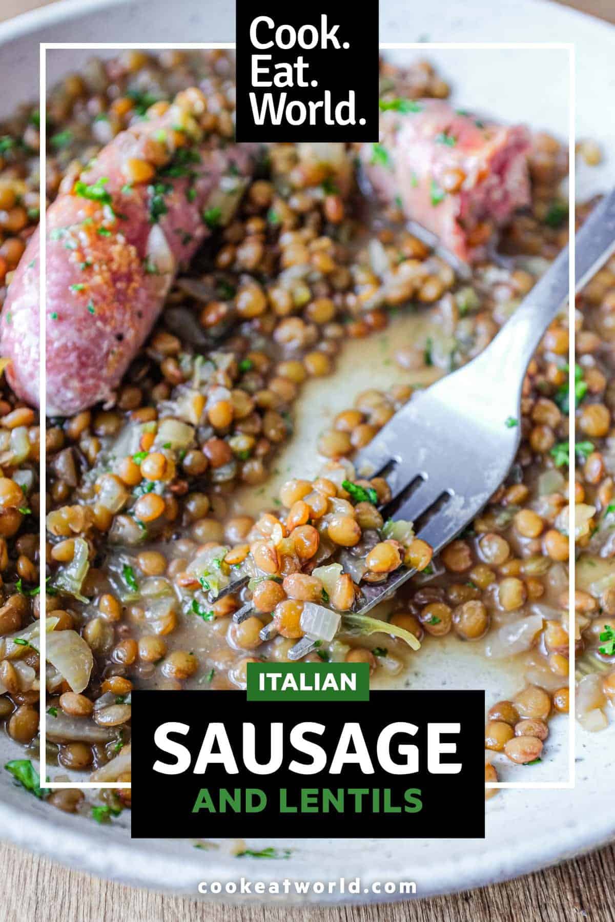 A shallow bowl has a layer of creamy lentils, topped with two Italian pork and fennel sausages. The dish is garnished with fresh parsley.