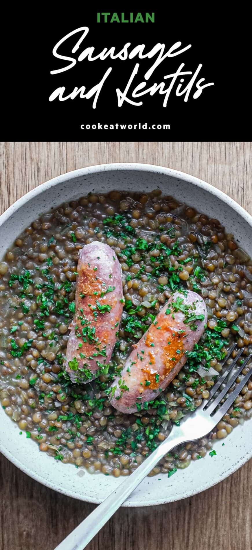 A shallow bowl has a layer of creamy lentils, topped with two Italian pork and fennel sausages. The dish is garnished with fresh parsley.