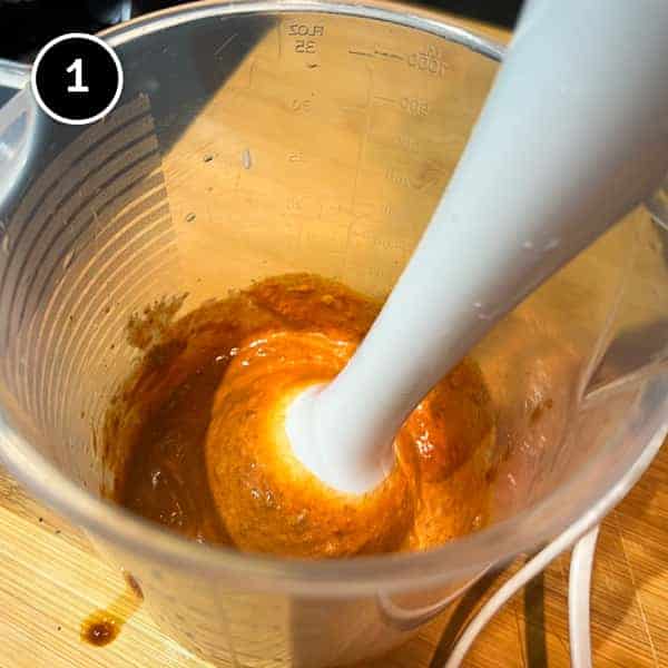 Blwnding chipotle peppers and sour cream with a stick blender in a jug