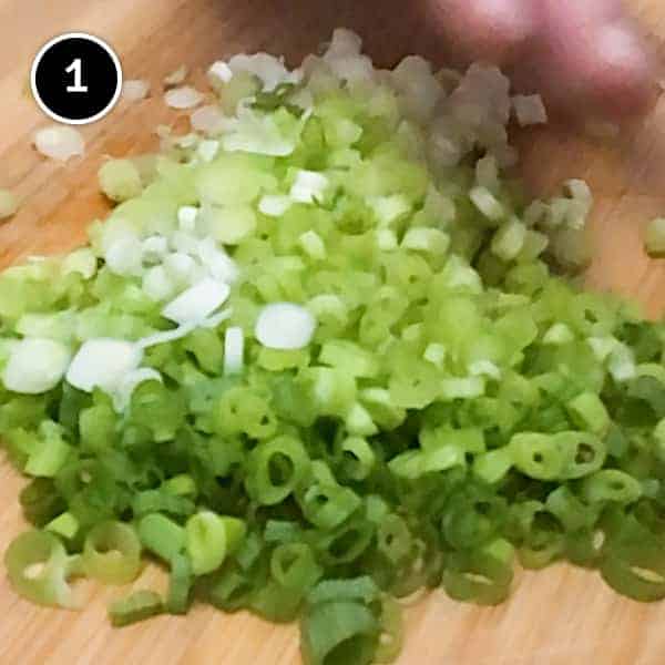 Chopping scallions finely on a chopping board