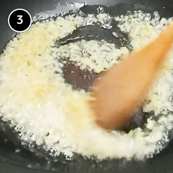 Frying finely diced fresh ginger in a wok