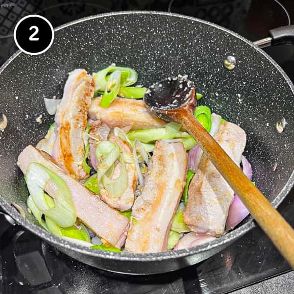 Stir frying pork belly and leeks in a large pan