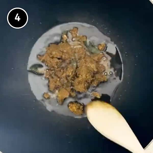 Frying beef balti curry paste in oil in a large kahari pan