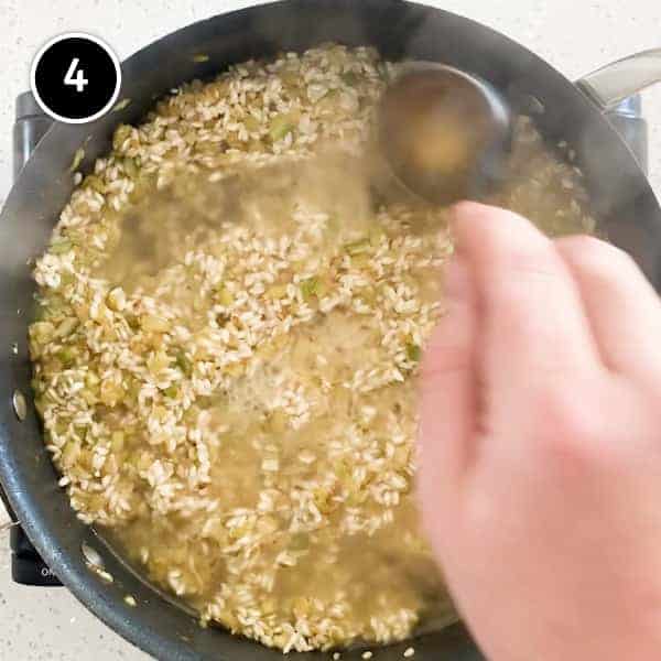 Adding stock with a small ladle to the fennel risotto