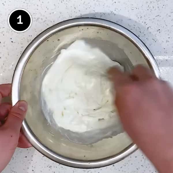 Whisking together yoghurt and garlic in a small bowl