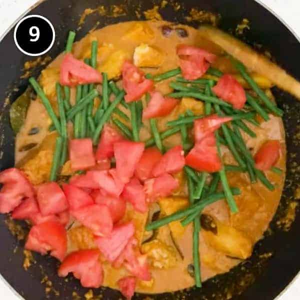 Adding Asian snake beans and fresh tomatoes to a creamy Malaysian fish curry.