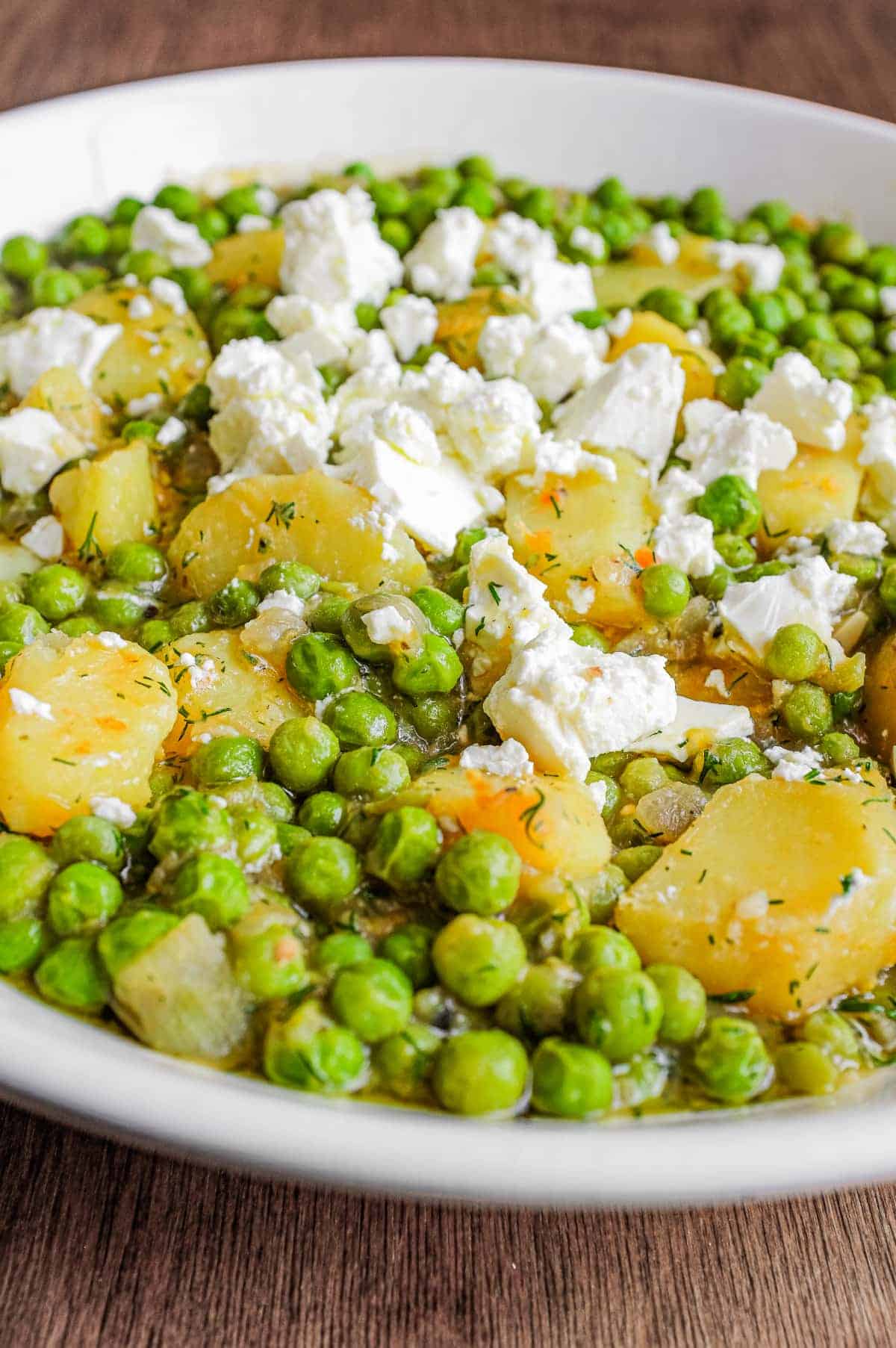 A bowl of Arakas Latheros (Greek Peas) garnished with feta cheese. 