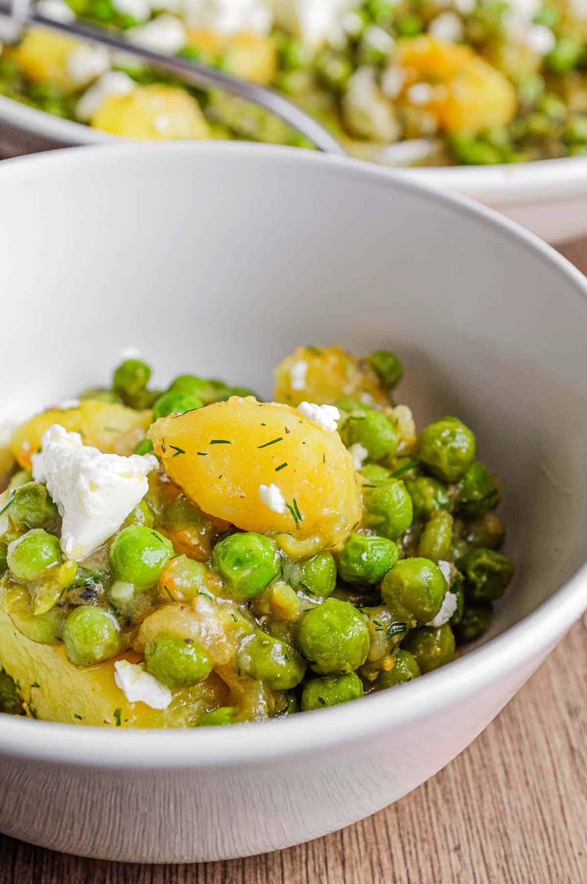 A small bowl of Arakas Latheros (Greek Peas). A larger bowl sits in the background.