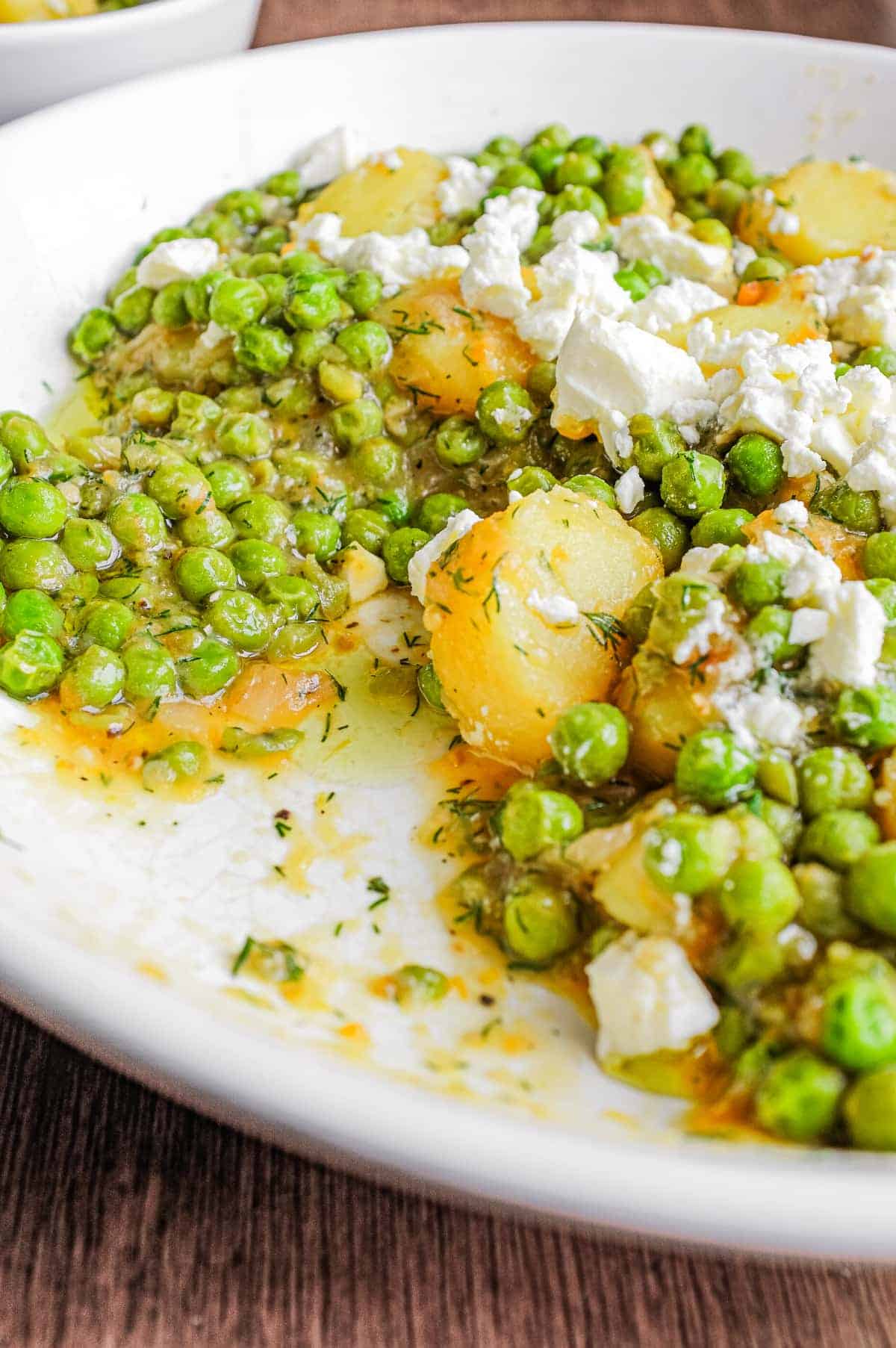 A bowl of Arakas Latheros (Greek Peas) garnished with feta cheese. 