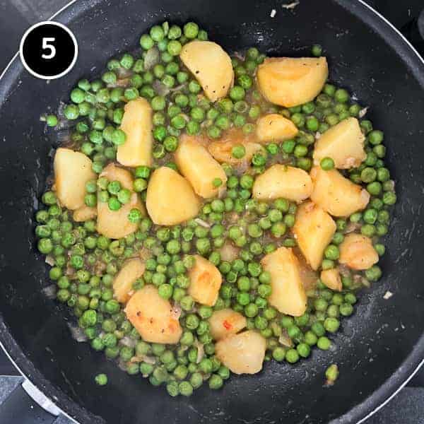 Peas and potatoes in a large pan. Taken from overhead