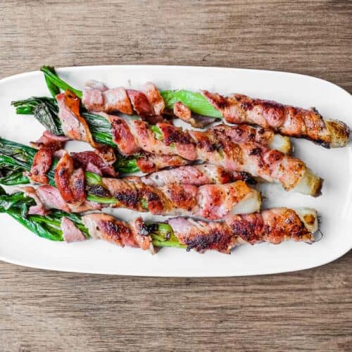 A platter of charred spring onions wrapped in pancetta