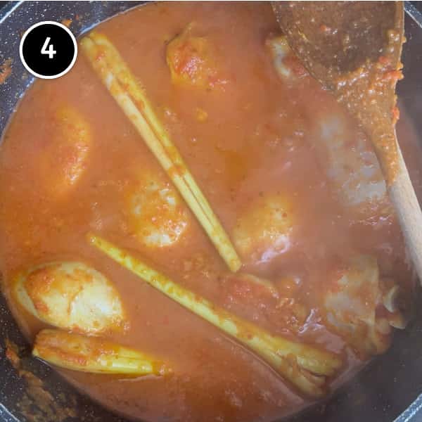 Chicken pieces simmering in a chilli sauce.