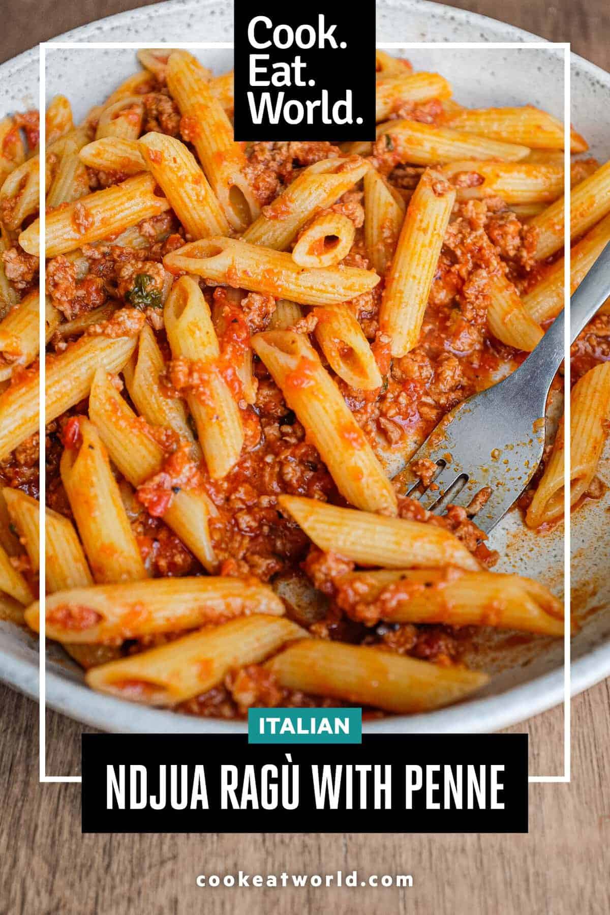 A bowl of nduja pasta sauce with penne pasta. A fork sits in the bowl too.