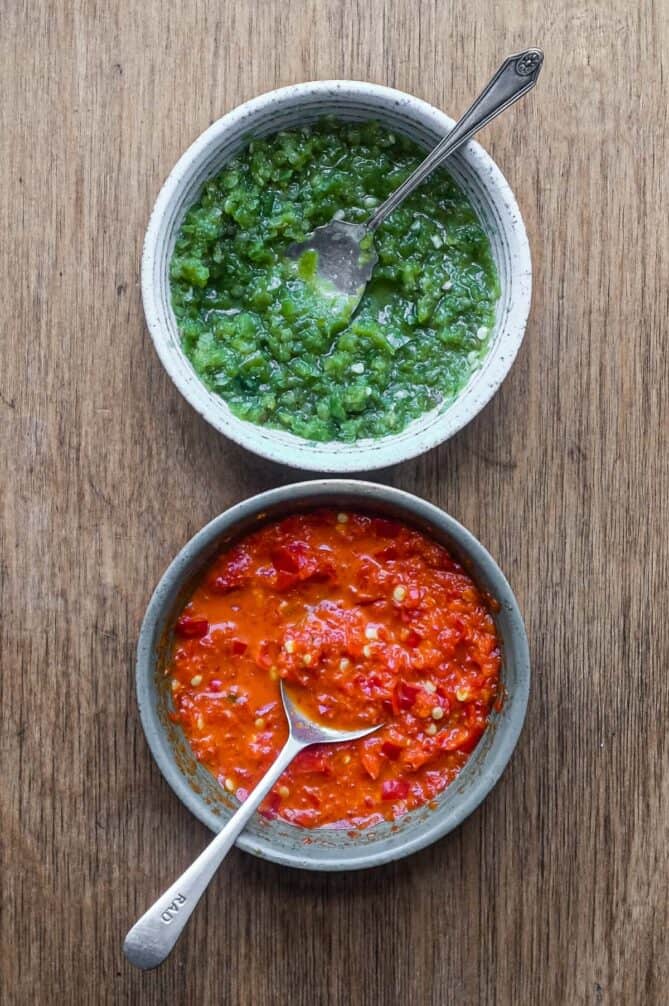 Two bowls of Middle Eastern Shatta Sauce. A red variety and green variety.