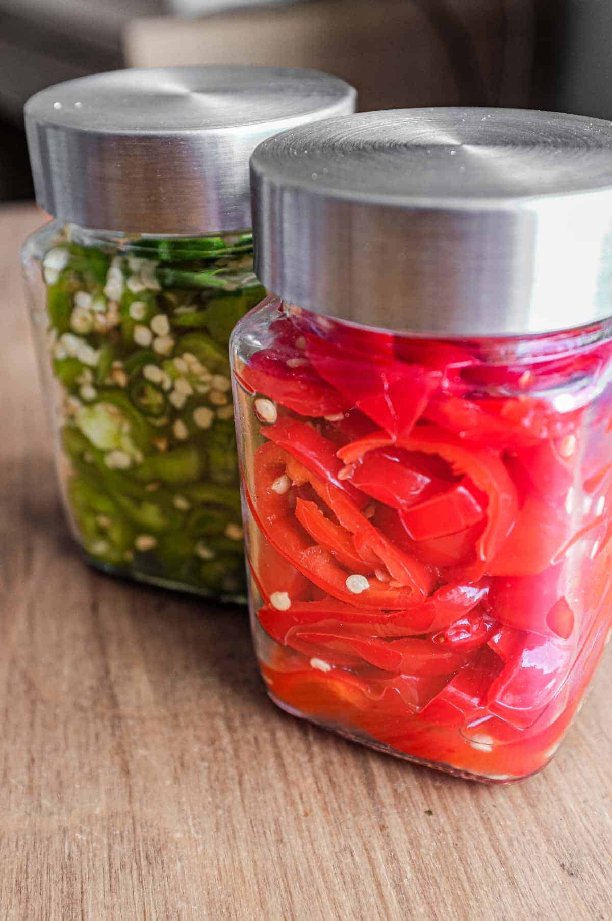 Two bowls of chillies ready for fermentation. A red variety and green variety.