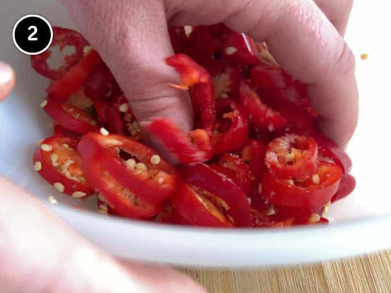 Mixing red chillies by hand in a bowl