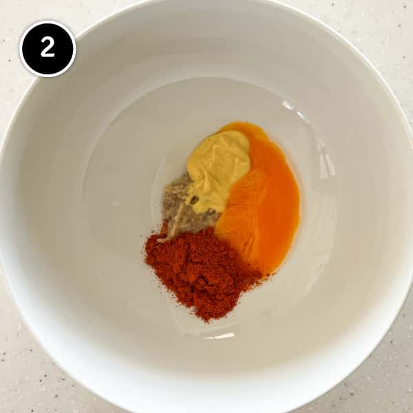 Egg yolk with garlic, anchovy, smoked paprika and mustard in a small bowl