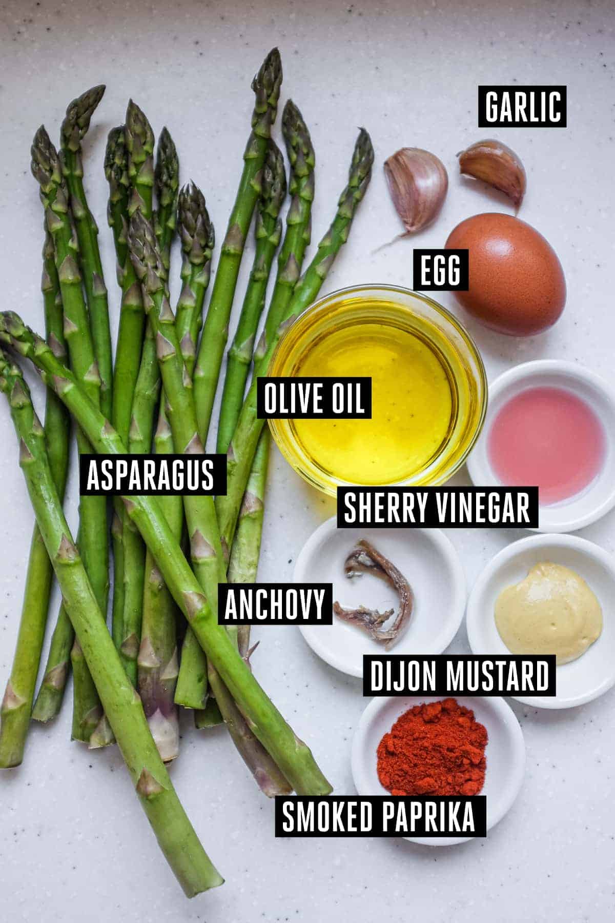 The ingredients for a tapas of asparagus with smoked alioli mayonnaise: Asparagus, olive oil, egg, mustard, garlic, anchovy, vinegar and smoked paprika.