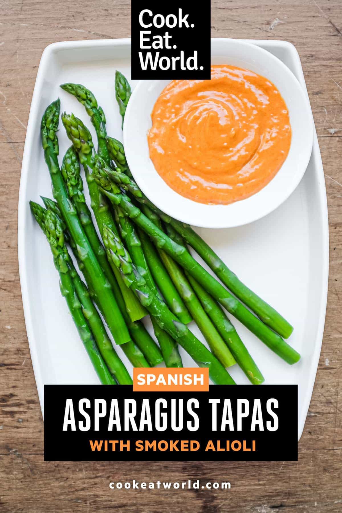 A small bowl of smoked alioli mayonnaise alongside some cooked asparagus
