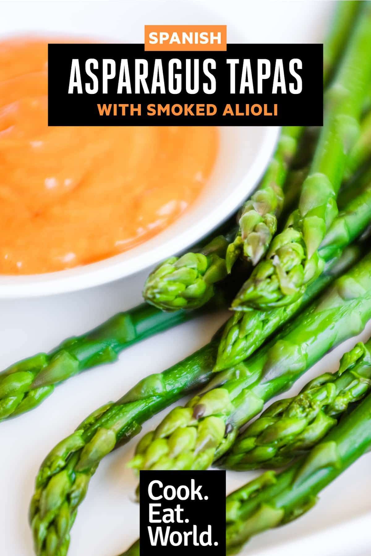A small bowl of smoked alioli mayonnaise alongside some cooked asparagus