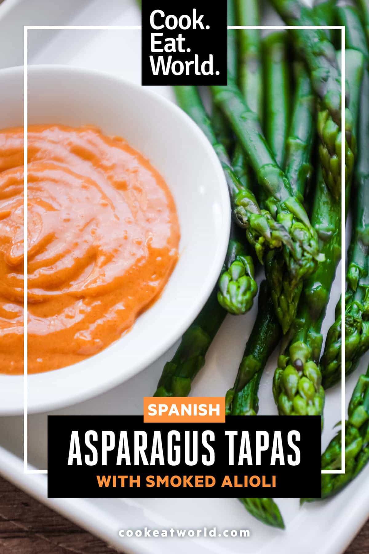 A small bowl of smoked alioli mayonnaise alongside some cooked asparagus