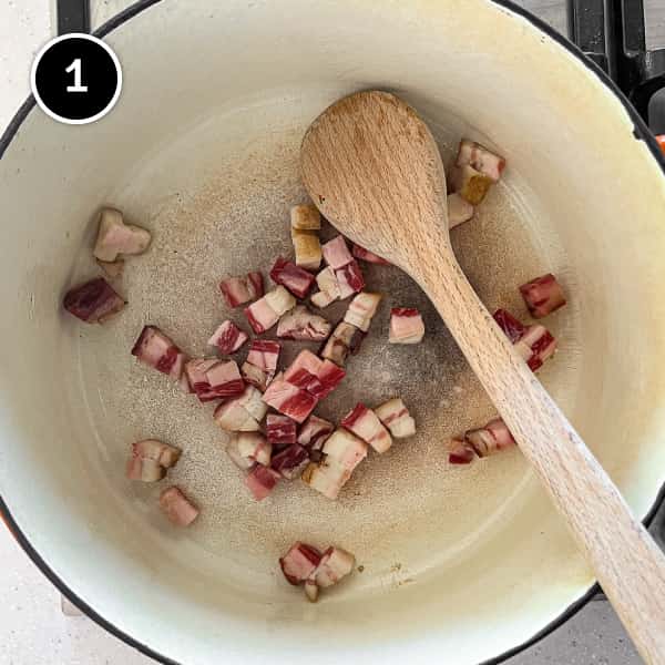 Bacon lardons frying in a pan