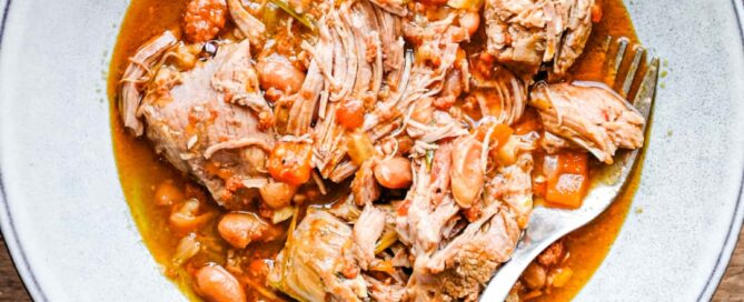 A bowl of Italian pulled lamb with beans with a fork