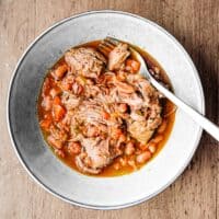A bowl of Italian pulled lamb with beans with a fork
