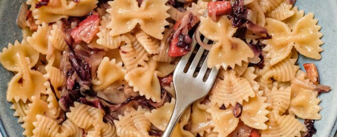 A bowl of farfalle pasta with a radicchio, pancetta and cheese sauce