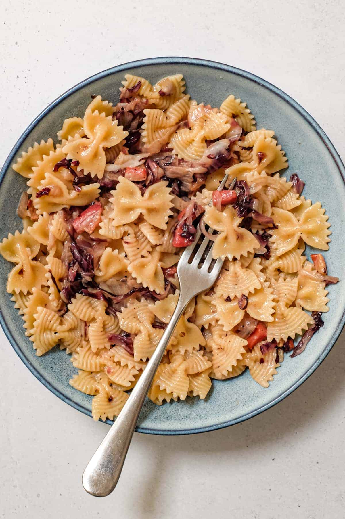 A bowl of farfalle pasta with a radicchio, pancetta and cheese sauce