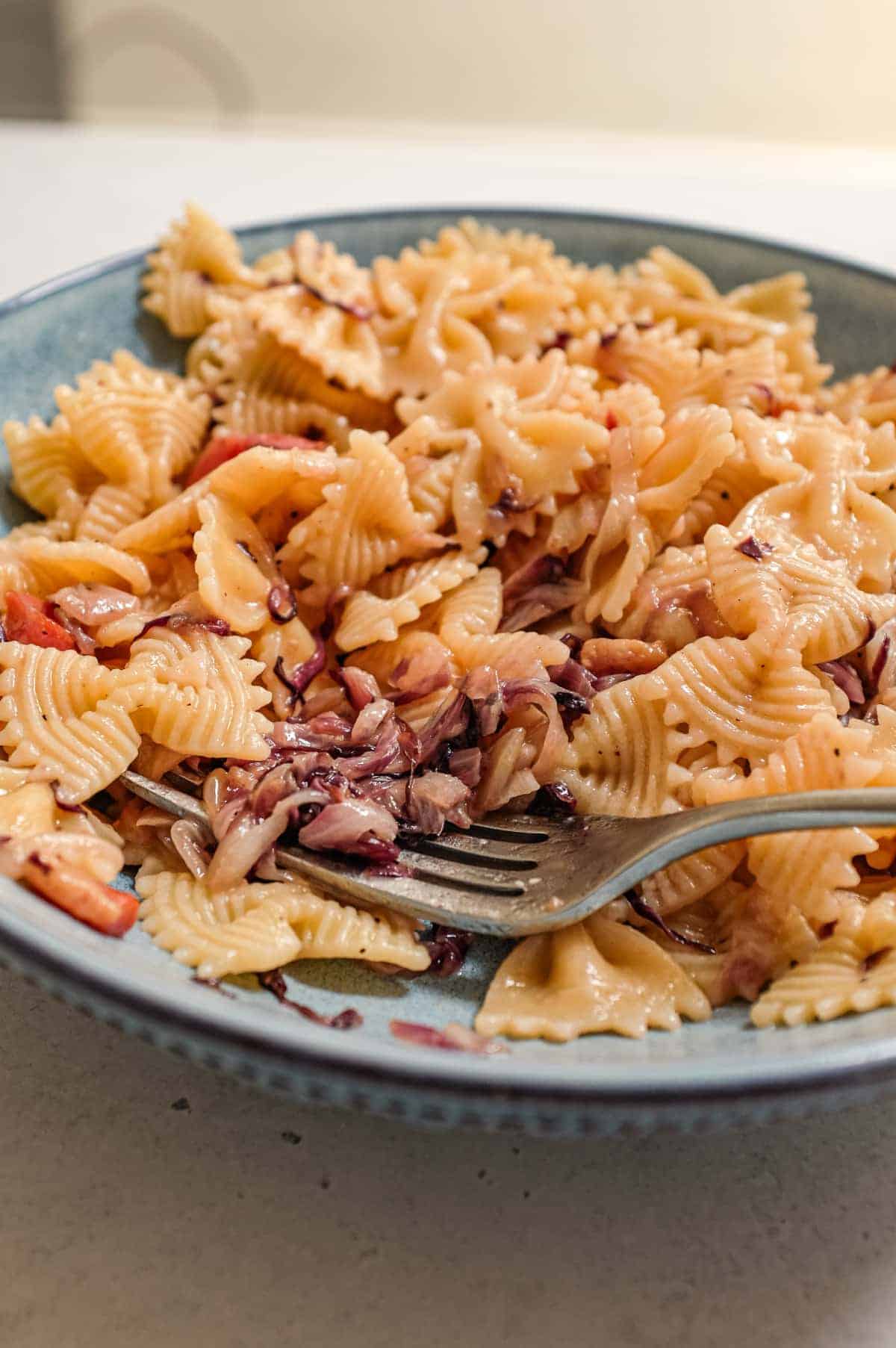 A bowl of farfalle pasta with a radicchio, pancetta and cheese sauce
