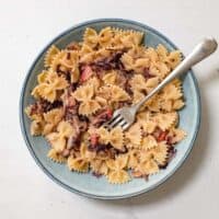 A bowl of farfalle pasta with a radicchio, pancetta and cheese sauce